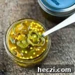 Small-Batch Cowboy Candy Canning Recipe for Spicy Candied Jalapeños 16 An open jar of cowboy candy with a spoon in it.