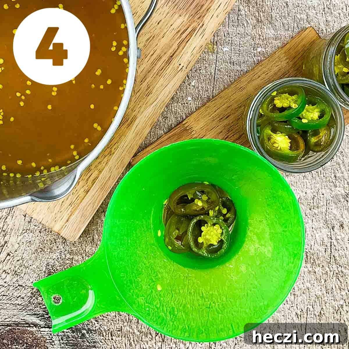 Small-Batch Cowboy Candy Canning Recipe for Spicy Candied Jalapeños 7 A wide mouth funnel on the mason jar with peppers inside.