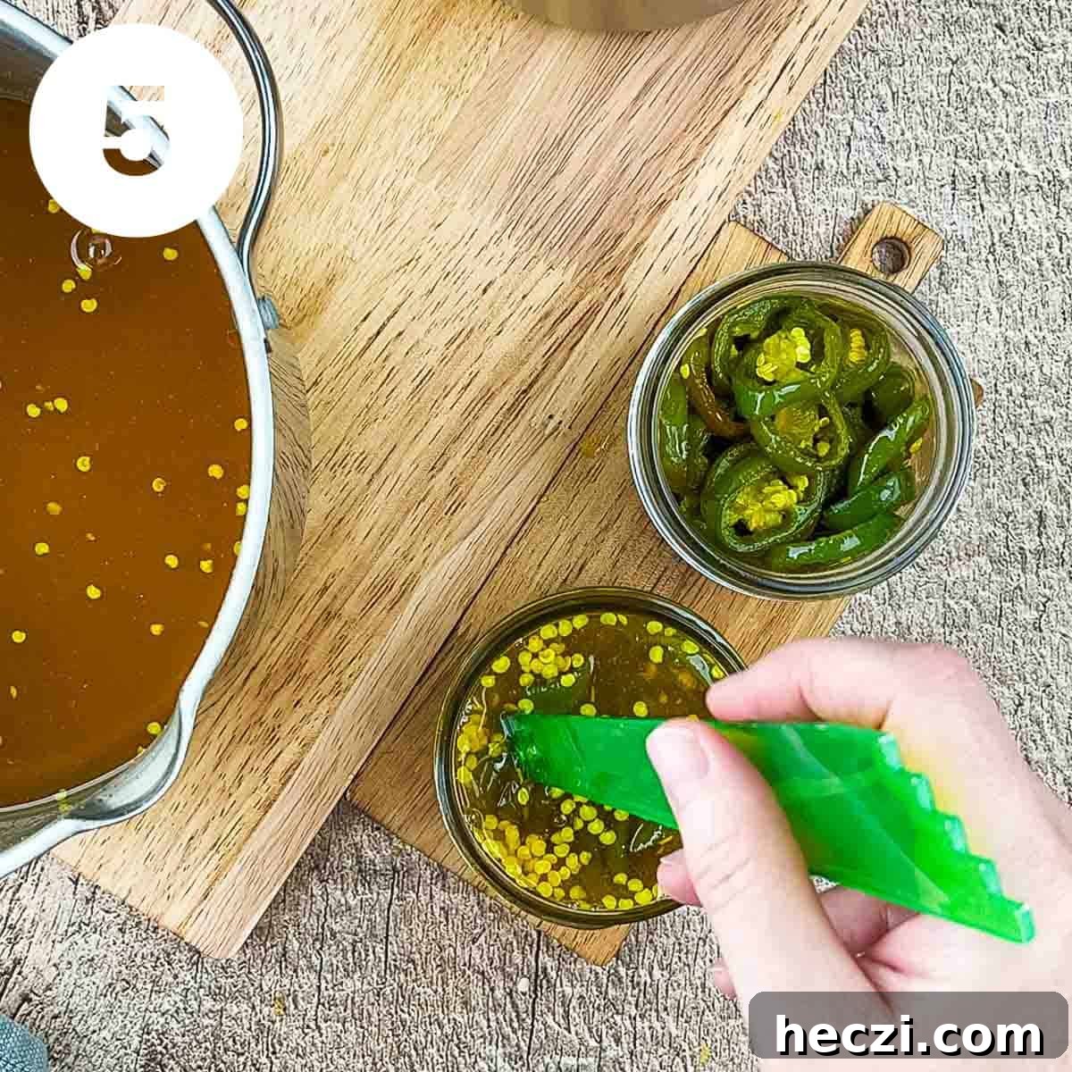 Small-Batch Cowboy Candy Canning Recipe for Spicy Candied Jalapeños 8 A tool removing air bubbles from the jar.