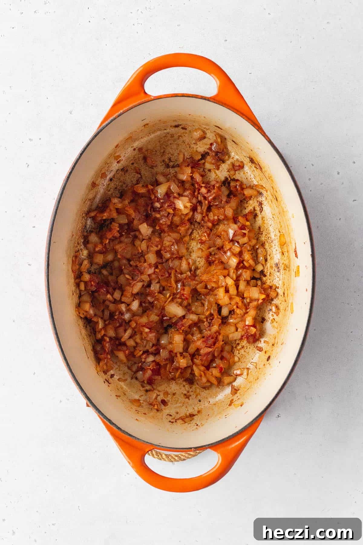 Add the spices and tomato paste to the onions.