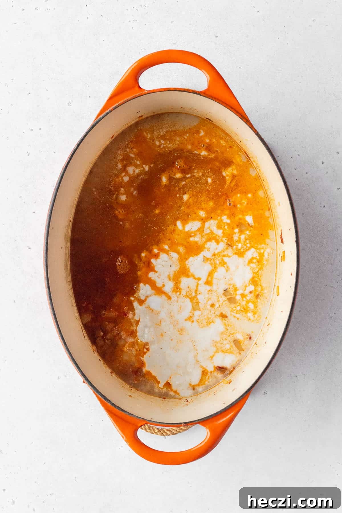 Vegetable stock and coconut milk added to the pot.