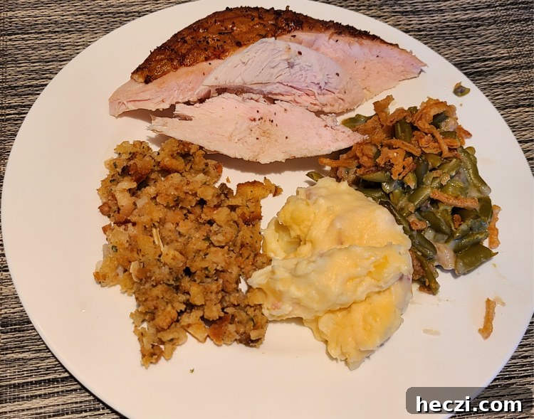 Smoked Green Bean Casserole served with mashed potatoes and stuffing on a white plate.  