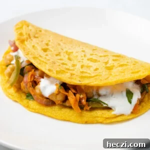A close up image of one piece of red lentil wraps on a white plate.