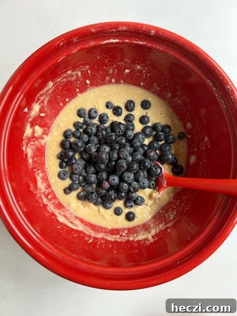 Frozen blueberries added to batter in the red bowl.