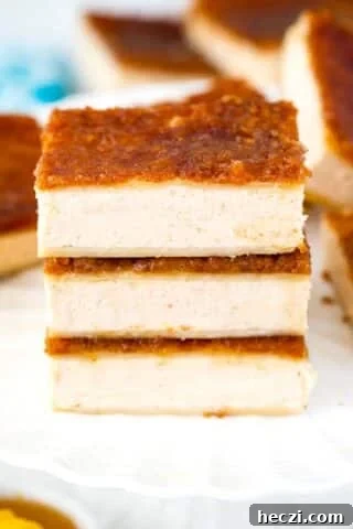 Three Sopapilla cheesecake bars stacked on a plate.