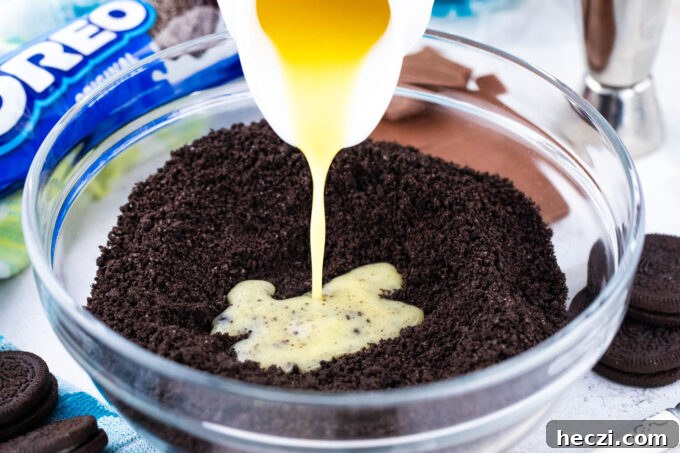 Adding melted butter to Oreo cookie crumbs.