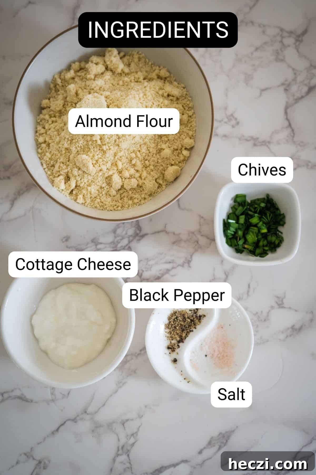 Cottage Cheese Crackers Recipe: Crispy Low-Carb Snack Guide 4 A bowl of almond flour, chopped chives, cottage cheese, black pepper, and salt in small dishes, labeled as ingredients on a marble countertop.