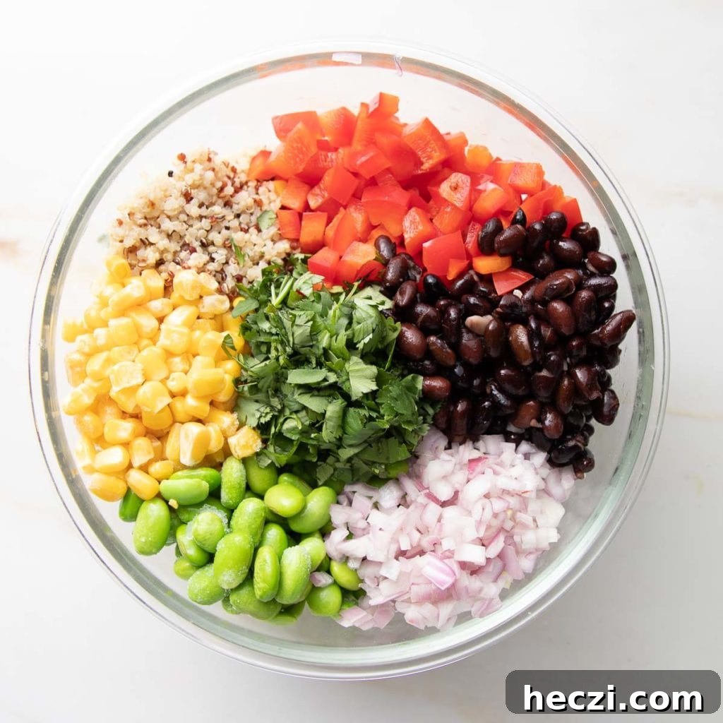 Quinoa, beans, edamame, corn, bell peppers and onions in a bowl.