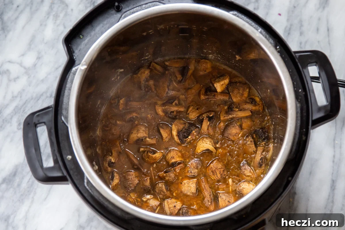 Garlic Mushrooms in the Instant Pot: Tender, Flavorful Side Dish 10 garlic mushrooms sauteeing in an Instant Pot