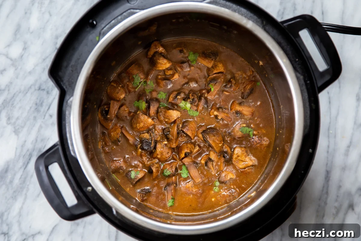 Garlic Mushrooms in the Instant Pot: Tender, Flavorful Side Dish 11 garlic mushrooms sprinkled with parsley in an Instant Pot