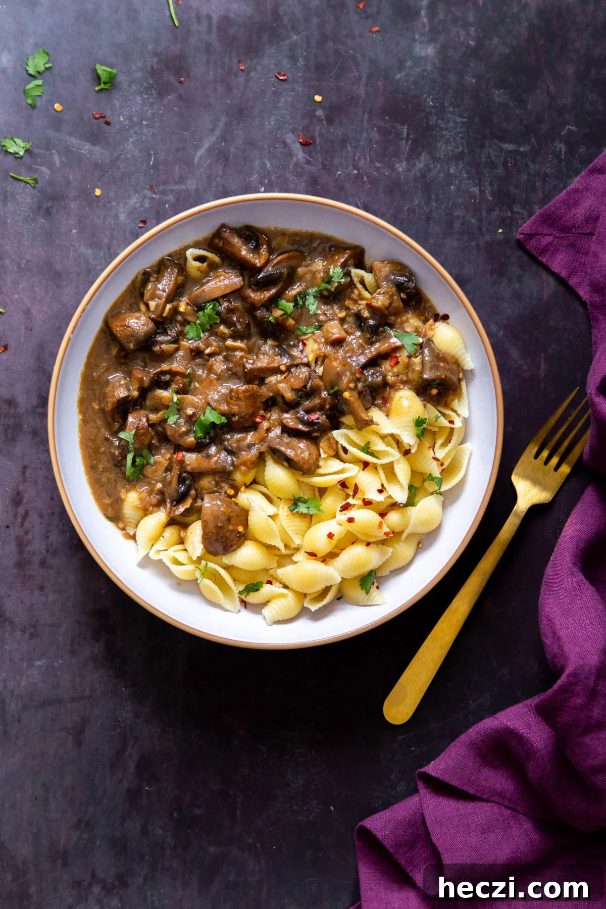 Garlic Mushrooms in the Instant Pot: Tender, Flavorful Side Dish 12 Instant Pot Garlic Mushrooms and shell pasta in a white bowl with a golden fork on the side