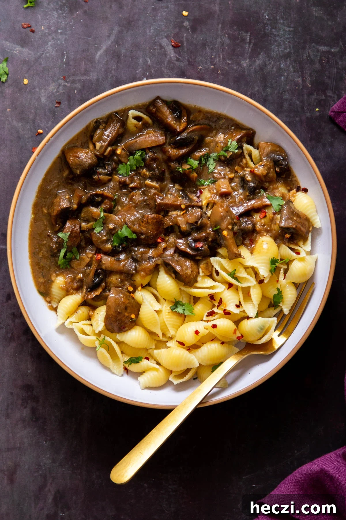 Garlic Mushrooms in the Instant Pot: Tender, Flavorful Side Dish 3 a white bowl with garlic mushrooms and pasta with a golden fork on the side