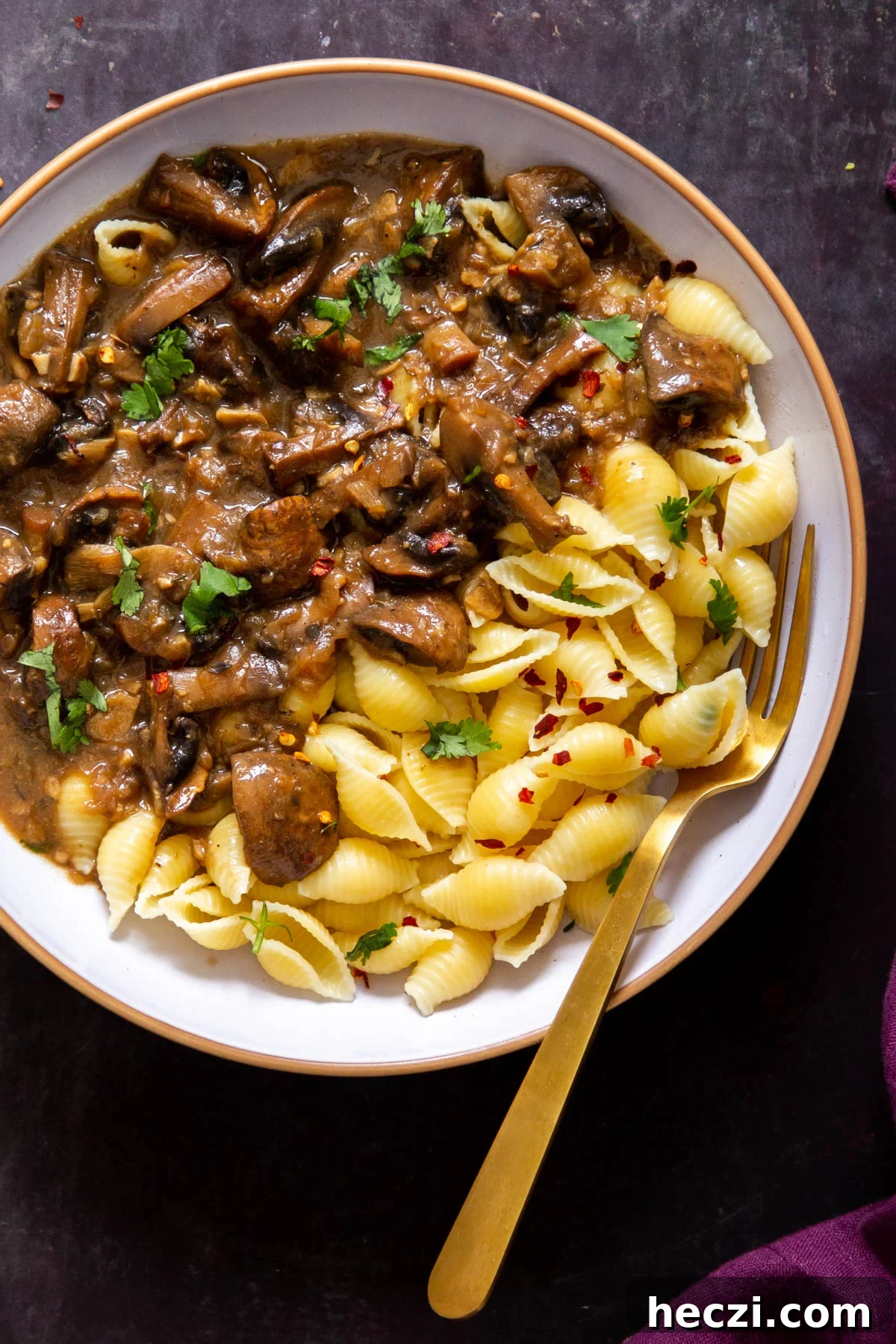 Garlic Mushrooms in the Instant Pot: Tender, Flavorful Side Dish 4 a white bowl with vegan Instant Pot garlic mushrooms served alongside shell pasta
