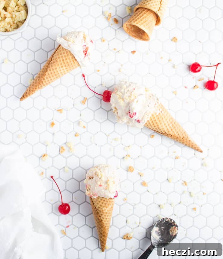 Pineapple Upside-Down Cake Ice Cream (No-Churn Recipe) 2 ice cream cones scattered across a tiled backdrop