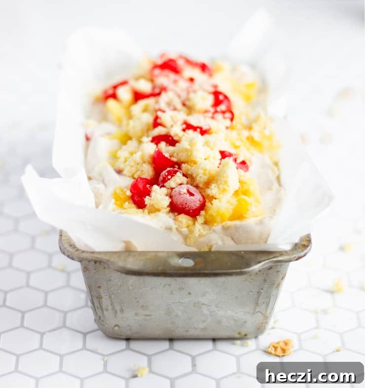 Pineapple Upside-Down Cake Ice Cream (No-Churn Recipe) 5 close up of ice cream in pan with toppings