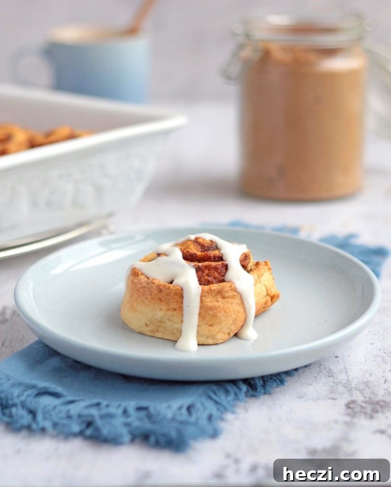 One Roll on a blue plate with Greek Yogurt Icing drizzled over