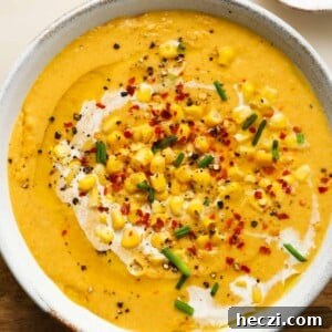 Creamy Corn Soup Recipe: Comforting, Silky Corn Chowder 5 Creamy corn soup garnished with chives, chili flakes, and whole corn kernels.