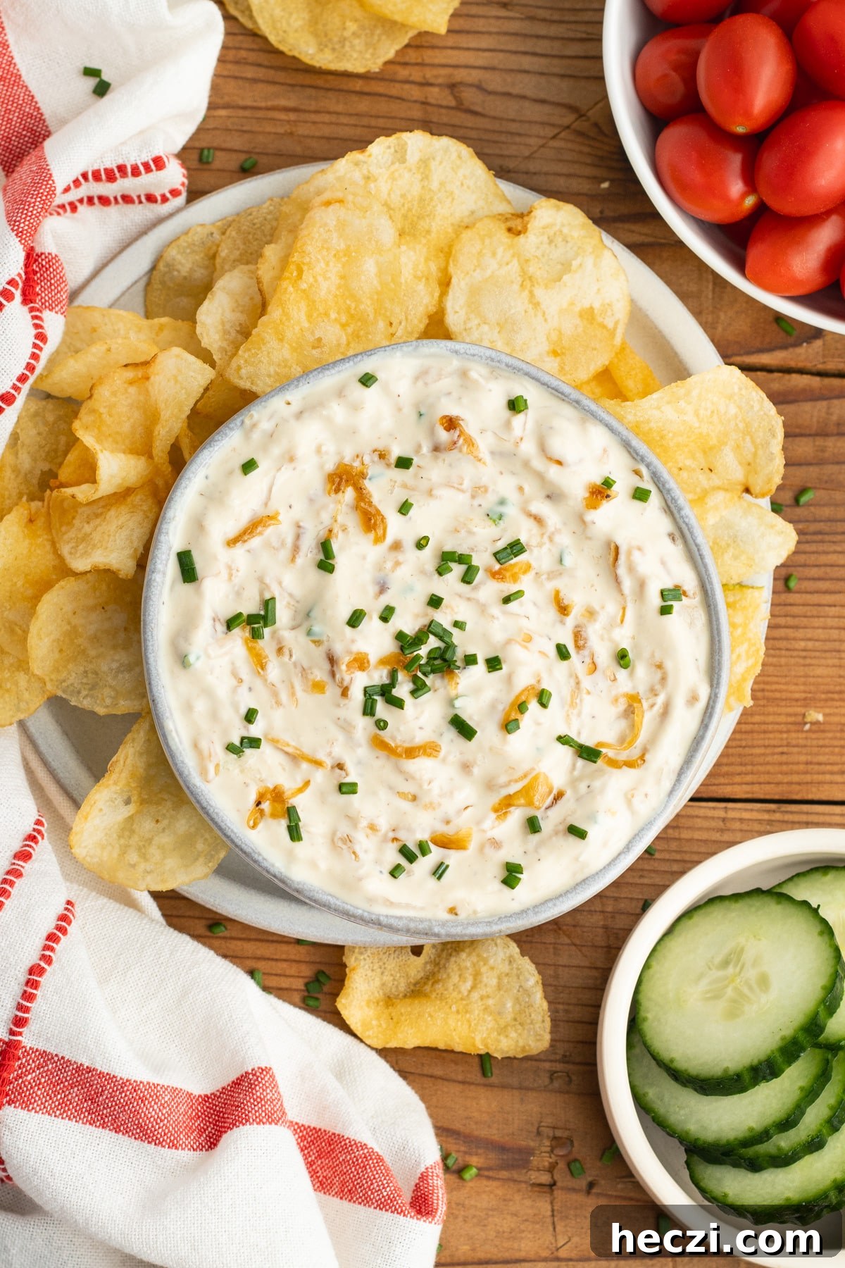 Caramelized Onion Dip with Greek Yogurt — Creamy Savory Recipe 13 This is a picture of a bowl with the onion dip, chips, tomatoes and cucumber.