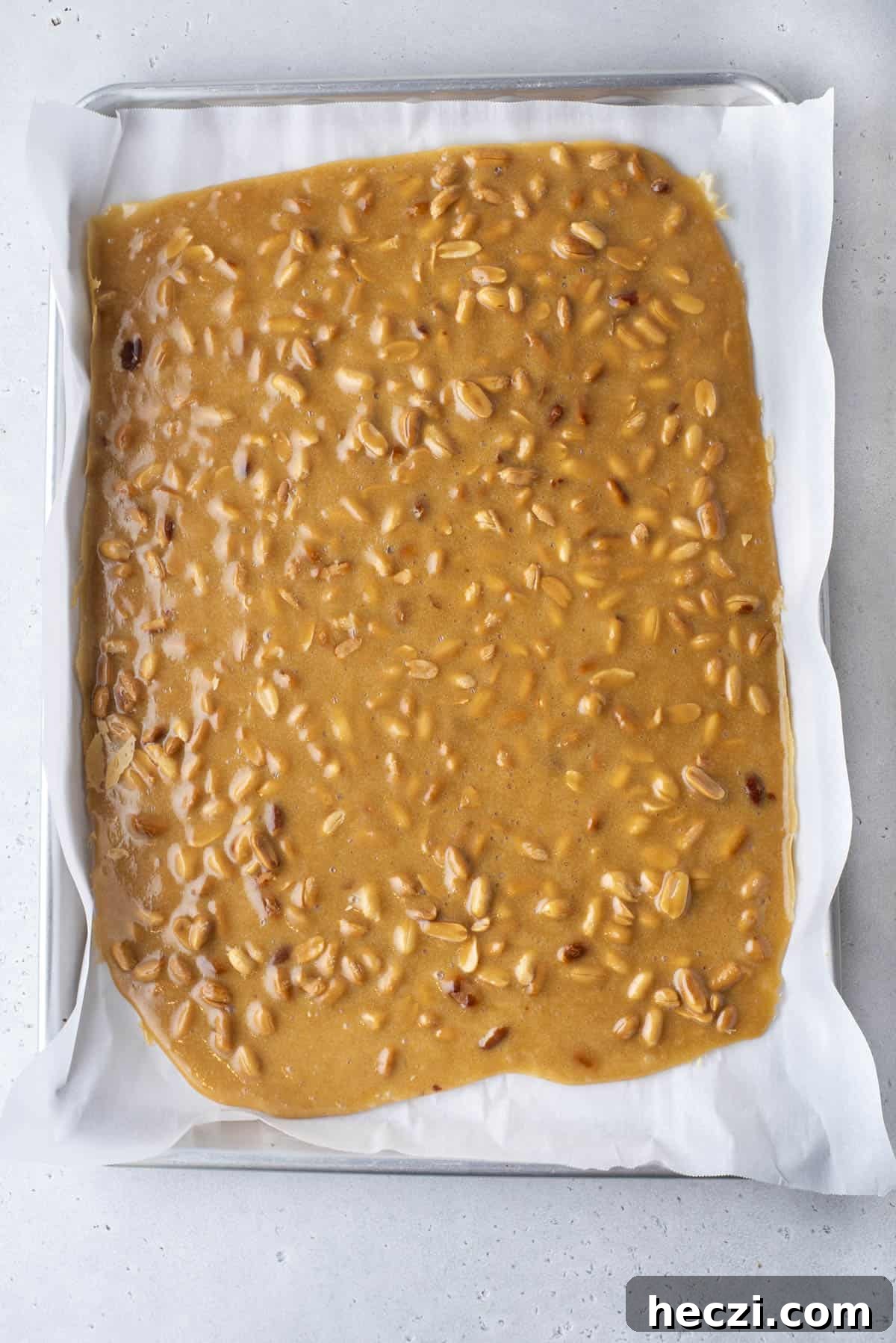 Classic Peanut Brittle Recipe: Crispy, Homemade Candy in 30 Minutes 15 peanut brittle mixture poured onto a baking sheet lined with parchment paper