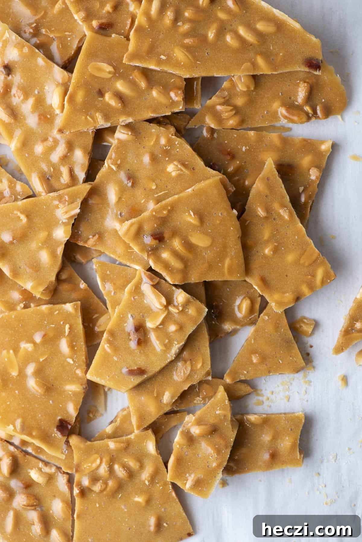 Classic Peanut Brittle Recipe: Crispy, Homemade Candy in 30 Minutes 18 peanut brittle pieces piled up on a countertop surface