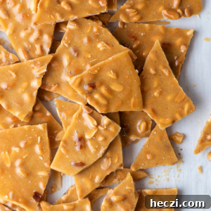 Classic Peanut Brittle Recipe: Crispy, Homemade Candy in 30 Minutes 19 peanut brittle pieces piled up on a countertop surface