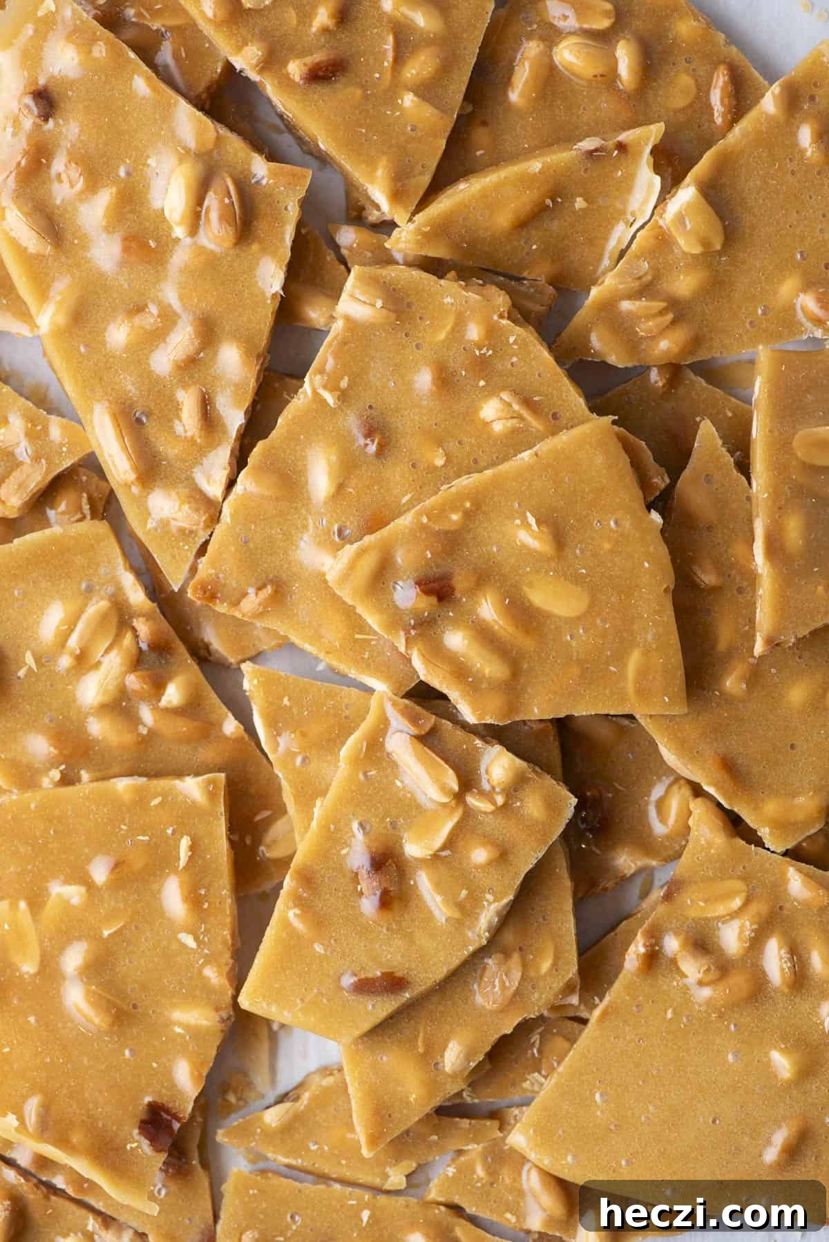 Classic Peanut Brittle Recipe: Crispy, Homemade Candy in 30 Minutes 7 close up of a pile of peanut brittle pieces on a countertop surface