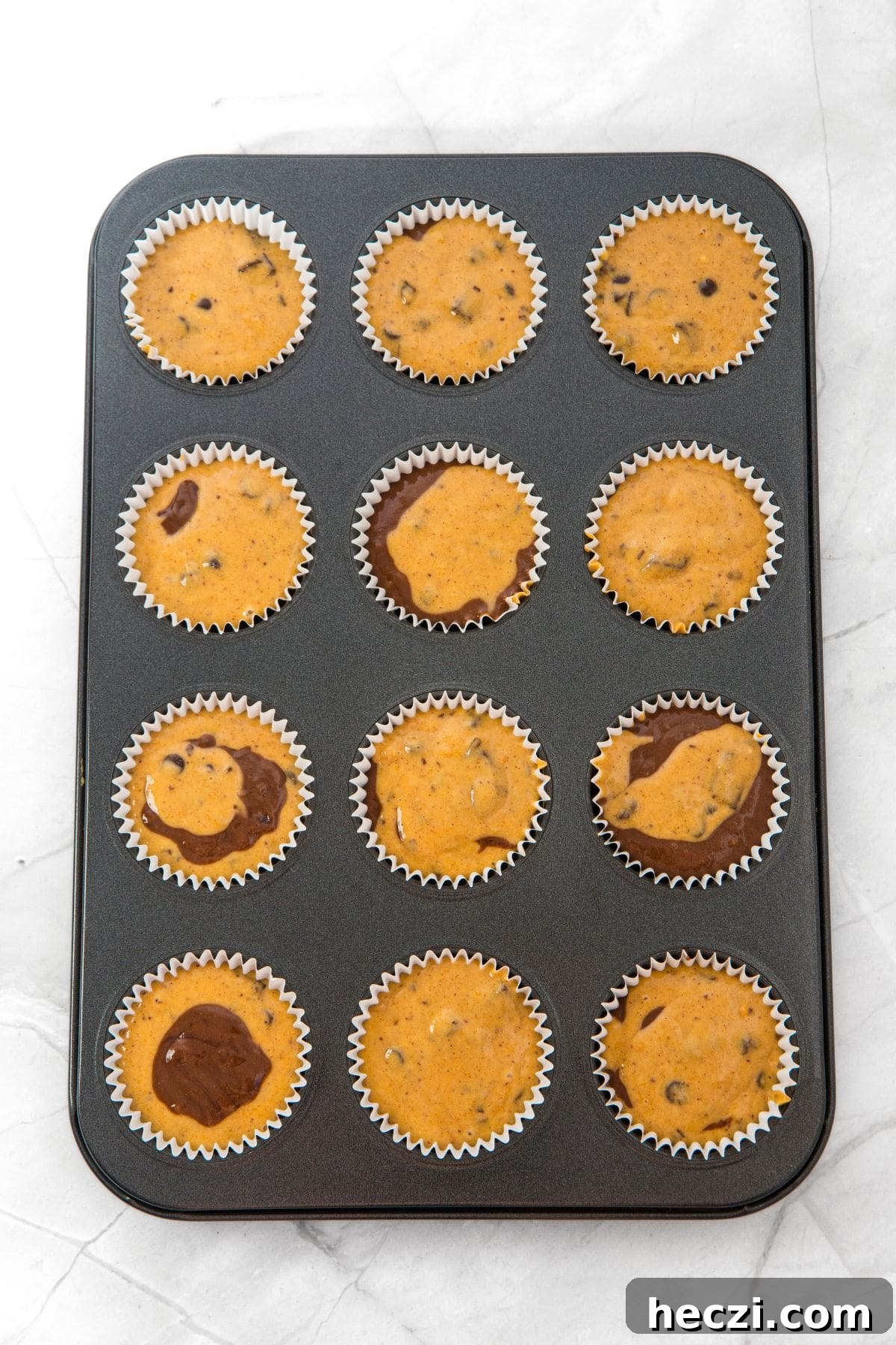 Pumpkin chocolate muffin batter in muffin pan