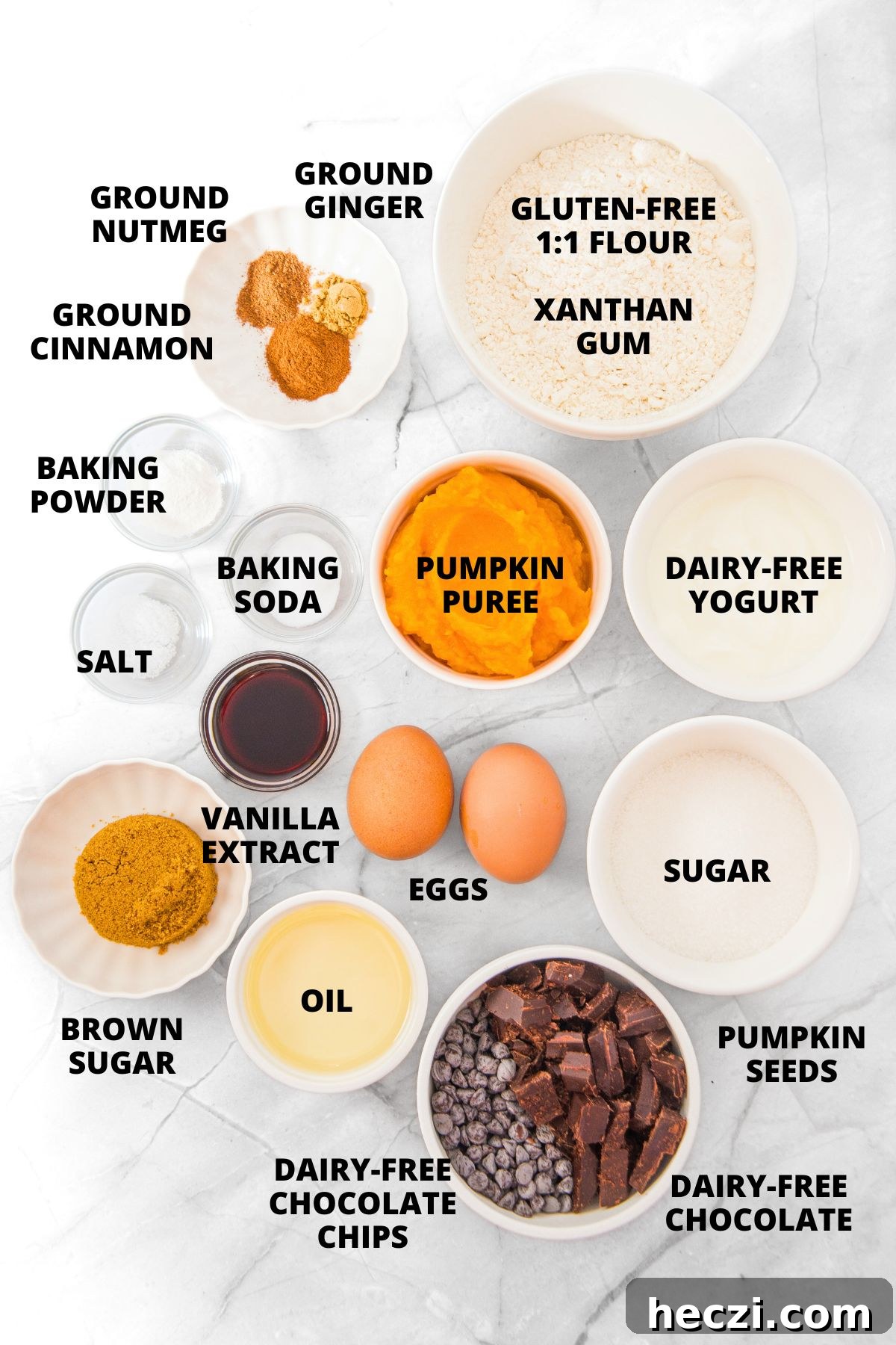 Ingredients for gluten-free pumpkin chocolate chip muffins recipe laid out on marble board.