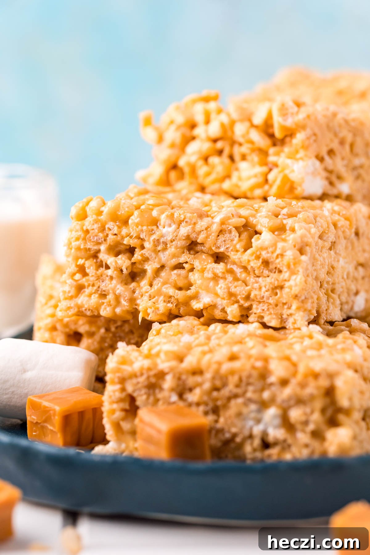 Salted caramel rice krispie treats stacked on a blue plate.