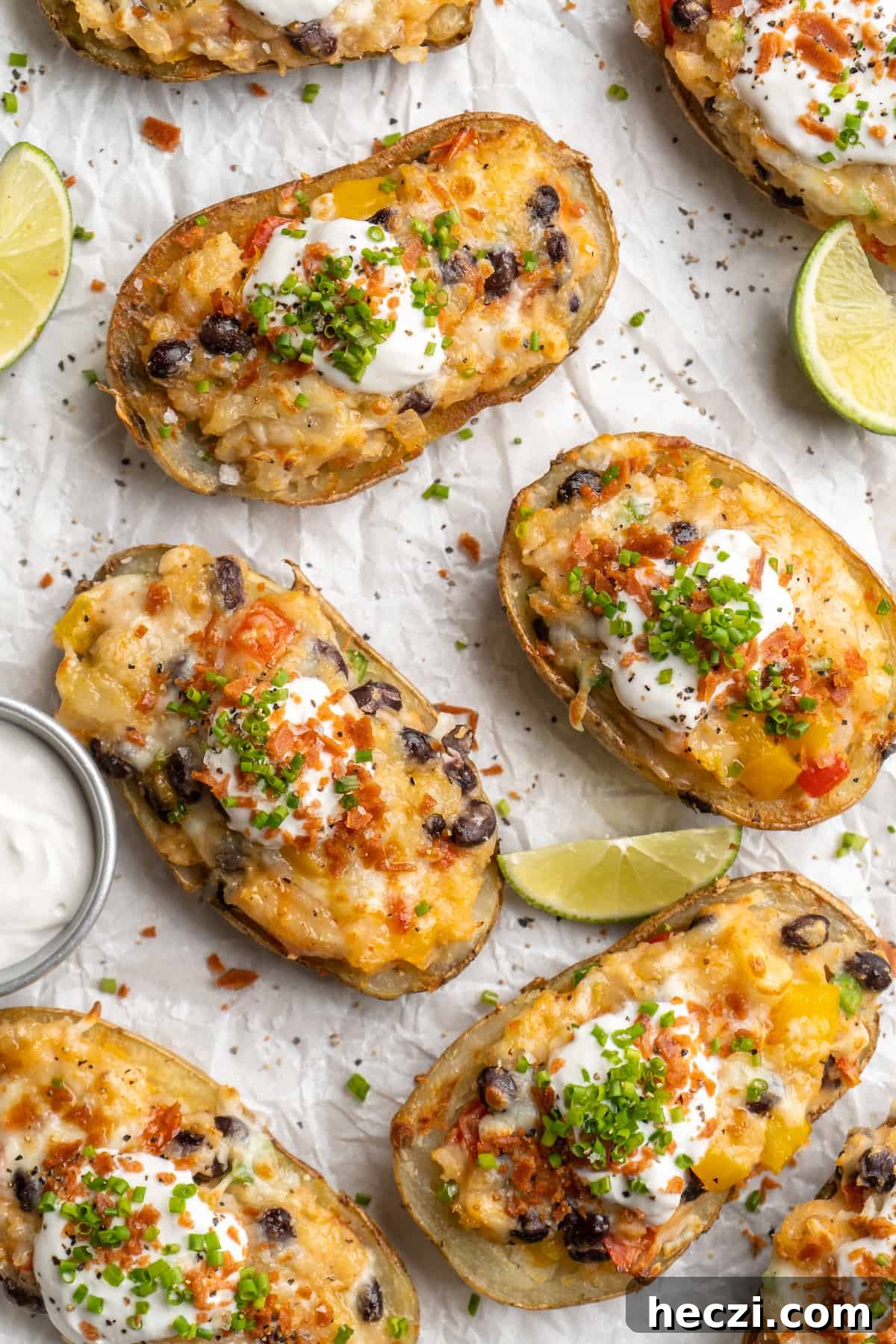 Loaded potato skins ready to serve. Overhead view of loaded potato skins on parchment-lined baking sheet