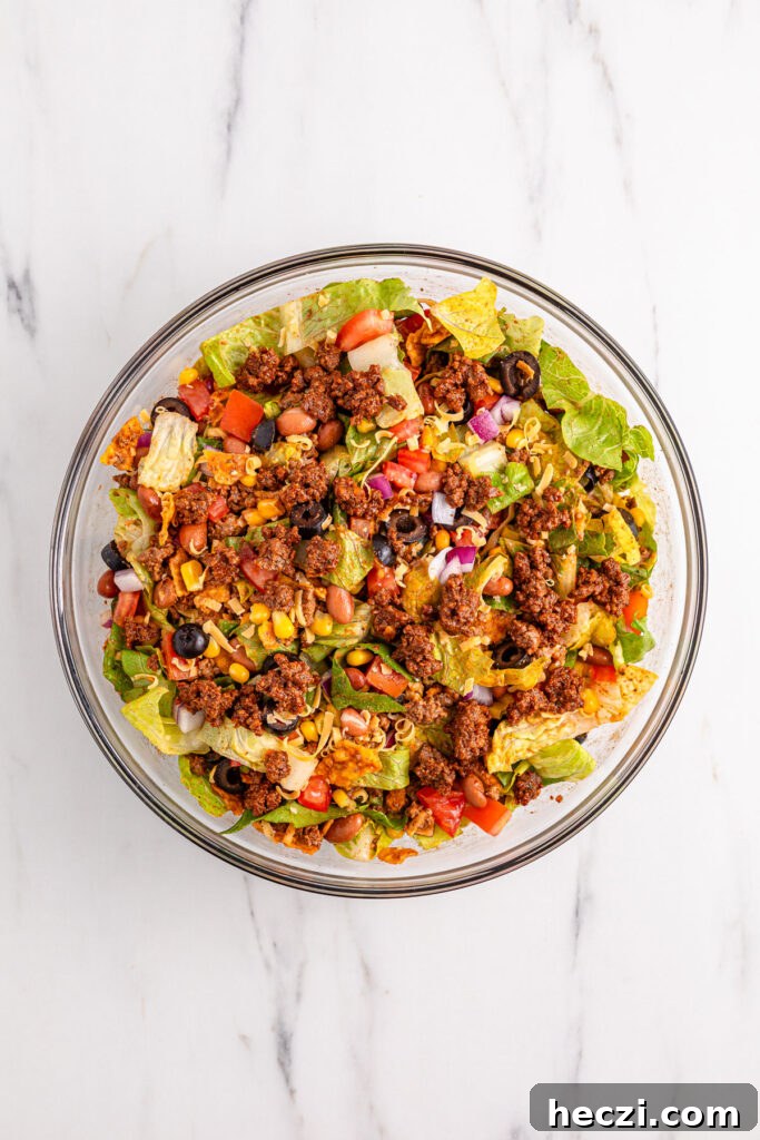 mixing Doritos taco salad in glass bowl