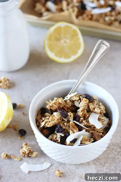 Lemon Blueberry Quinoa Granola Lemon Blueberry Granola in a white bowl with lemon halves to the side.