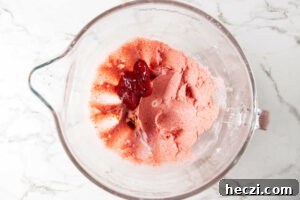 Strawberry Cream Cheese Frosting Recipe for Cakes & Cupcakes 8 Mixing strawberry jam into buttercream mixture.
