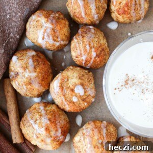 Air Fryer Cinnamon Roll Bites Made with 2-Ingredient Dough 12 Cinnamon roll bites on parchment paper with a greek yogurt glaze dip.