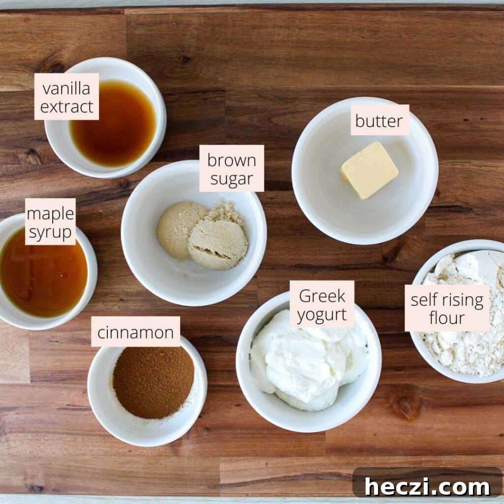 Air Fryer Cinnamon Roll Bites Made with 2-Ingredient Dough 3 Self-rising flour, Greek yogurt, butter, brown sugar, cinnamon, maple syrup and vanilla extract in small bowls.