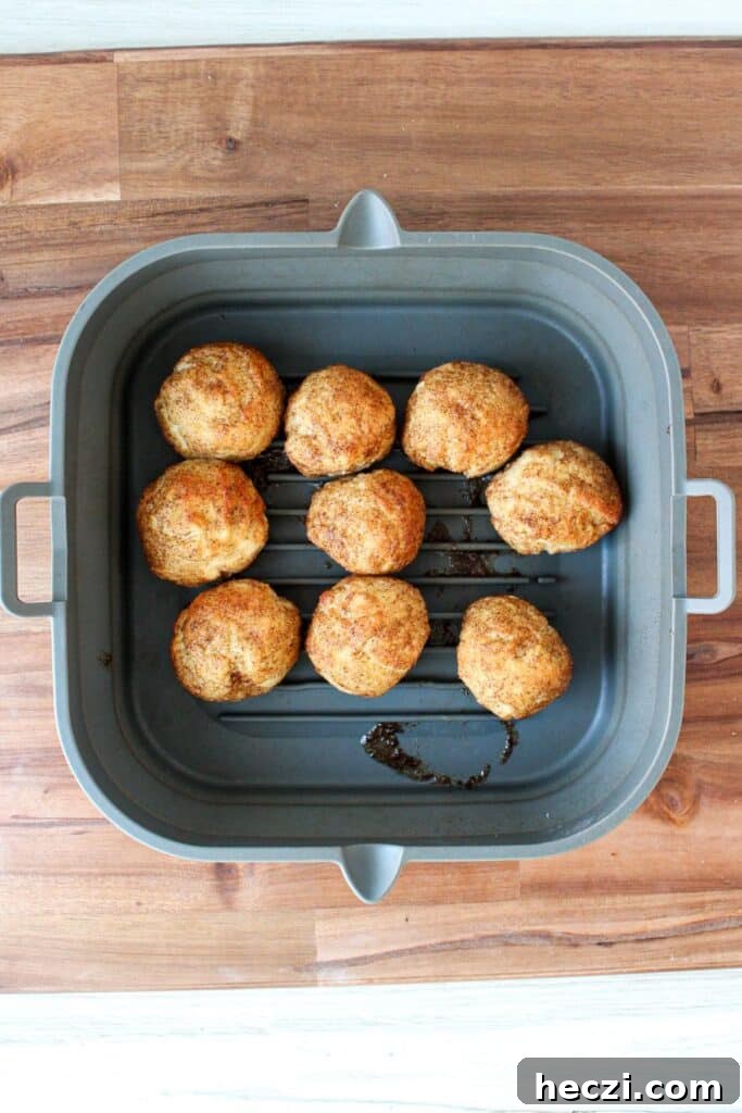 Air Fryer Cinnamon Roll Bites Made with 2-Ingredient Dough 10 Air fryer cinnamon roll bites in a silicone air fryer liner.