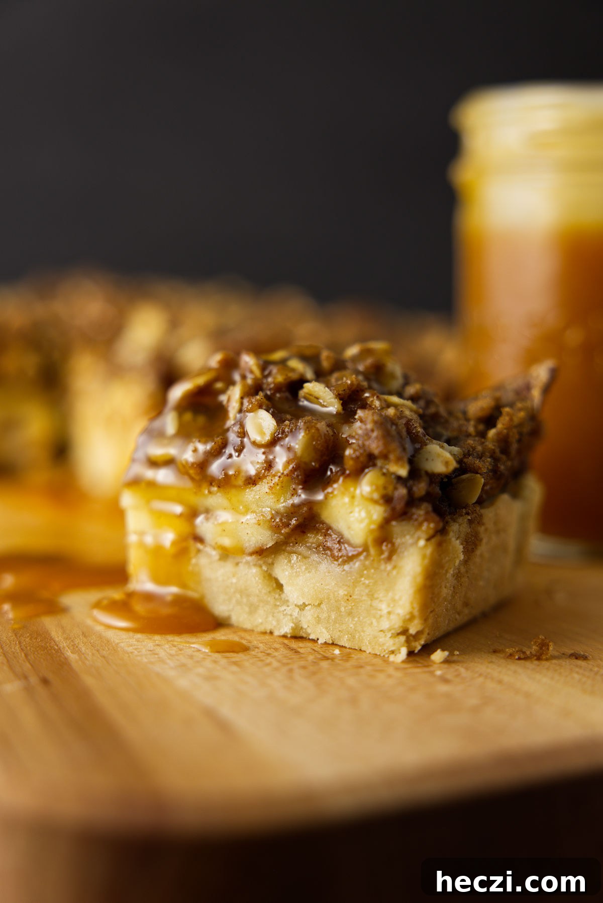 Chewy Apple Crisp Bars with Cinnamon Streusel 12 A slice of apple bar with a crispy oat streusel on top and a drizzle of caramel sauce.