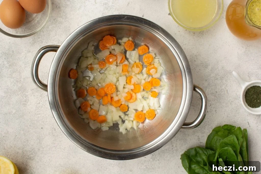 sauteing chopped carrots and onions in a large soup pot for chicken orzo soup