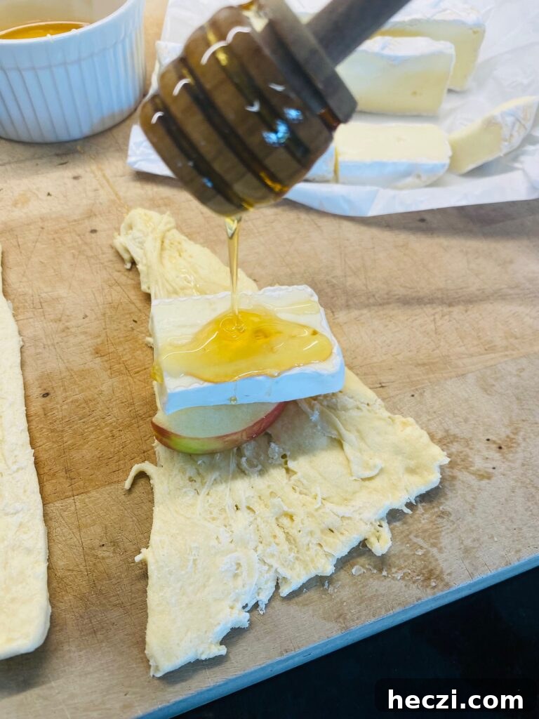Crispy Apple and Brie Roll-Ups with Honey Dijon Dip 4 adding apple, cheese slice, and honey