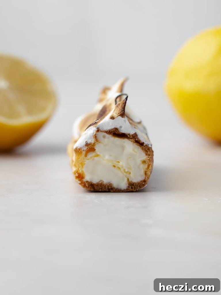 Gluten Free Lemon Meringue Éclairs cut in half with the lemon mousse showing