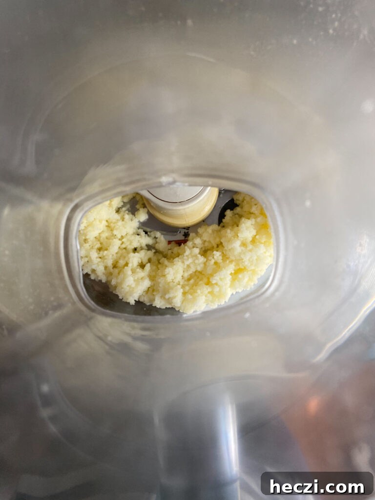 Turn your food processor on and add your egg mixture slowly through the feeder. Don’t add it all at once.