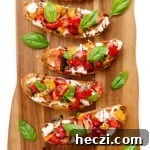Burrata Bruschetta with tomato basil topping on a wooden board.