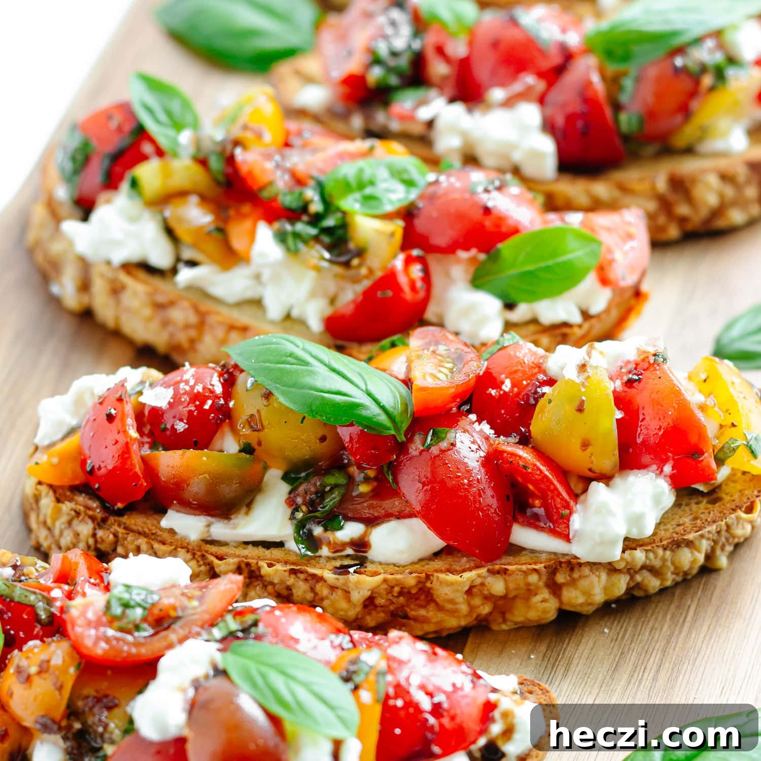 Tomato basil burrata bruschetta on a wooden board.