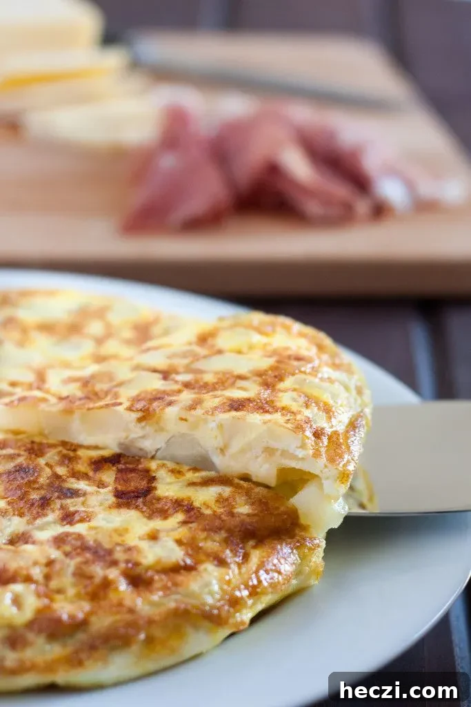 Spanish Omelette Recipe: Classic Tortilla Española Guide 2 Tortilla Espanola - Spanish Tortilla - is a classic egg and potato dish with infinite variations served all over Spain and in some parts of the Caribbean. An easy budget meal, tortilla can be served any time of day, or cut into cubes and served as a party appetizer! Recipe and variations on GoodieGodmother.com