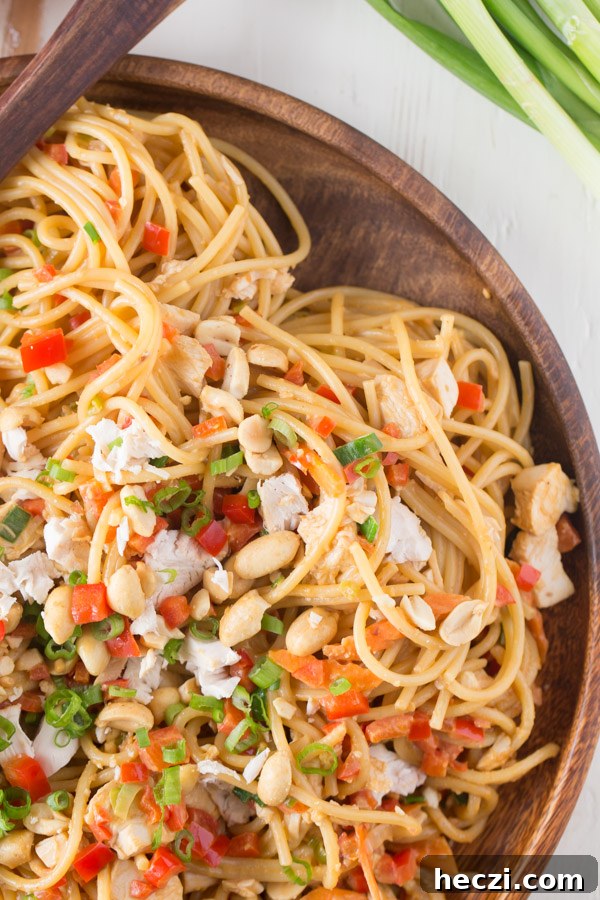 Easy Spicy Peanut Noodles With Chicken on a wood serving plate.