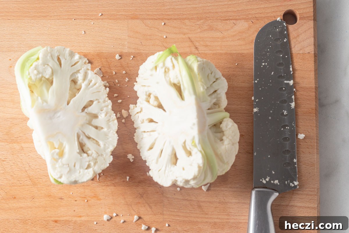 cutting cauliflower into two with a sharp knife.