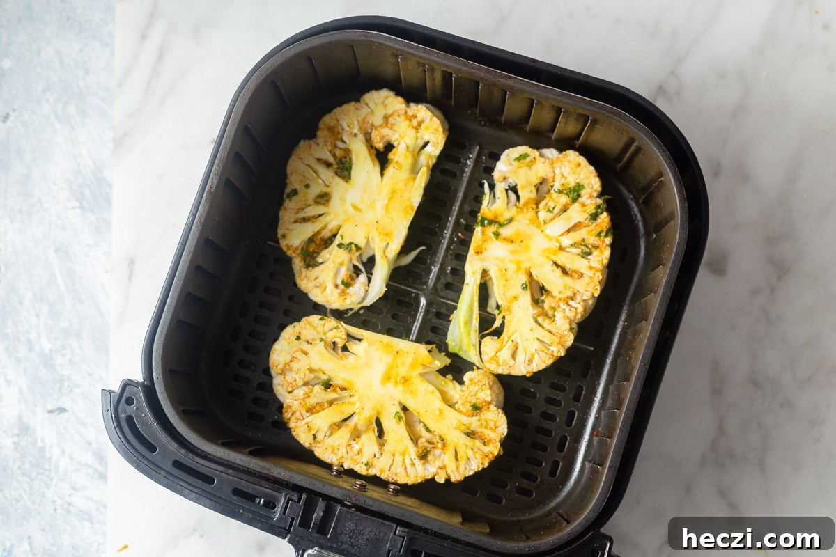 cauliflower steaks in the air fryer basket.