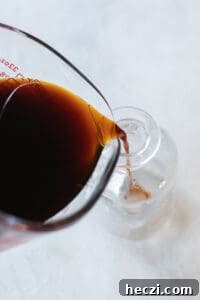 Homemade Gingerbread Syrup Recipe for Coffee & Cocktails 11 pouring syrup into glass jars