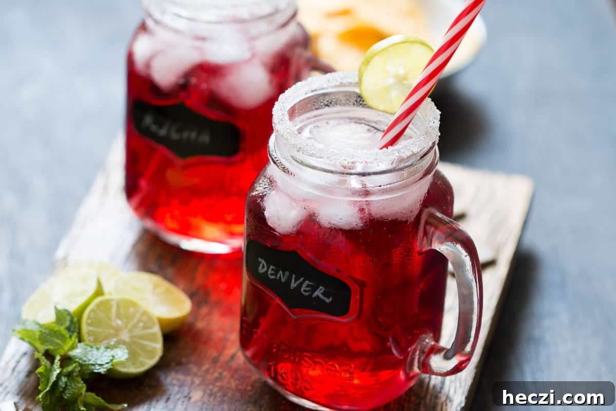 Cranberry Ginger Holiday Cocktail served in mason jars with sugar coated rims and a slice of lime.