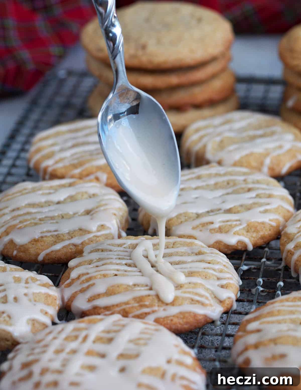 Chai-Spiced Eggnog Cookies Recipe for the Holidays 6 glaze being drizzled on an eggnog cookie with a spoon